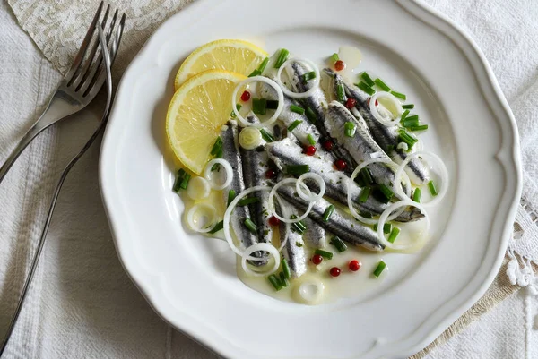 Marinated sardine fillets in white plate. White sardine fillets. Healthy seafood. Vegetarian food.