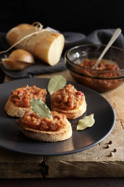 Zacusca - Romanian food. Slices of bread with vegetable spread, roasted eggplant, onions, tomato paste and roasted red peppers. Autumn and vegetarian food.