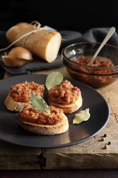 Zacusca - Romanian food. Slices of bread with vegetable spread, roasted eggplant, onions, tomato paste and roasted red peppers. Autumn and vegetarian food.