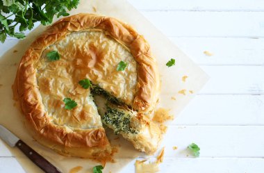 Traditional Greek cuisine. Spanakopita, savory pie. Homemade Greek phyllo dough pie filled with spinach and feta cheese. Close-up.