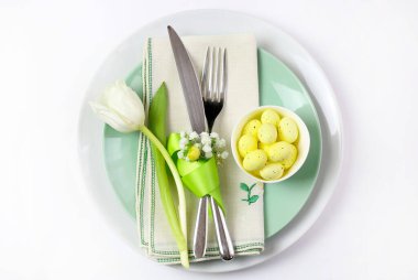 Concept of Easter holiday. Easter table with cutlery on white background. Directly above.