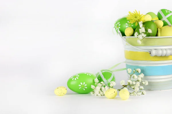 Concept of Easter holiday. Easter eggs and flowers in basket isolated on white background. Copy space