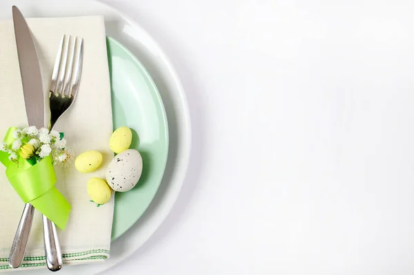 Concept of Easter holiday. Easter table with cutlery on white background. Directly above.