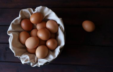 Ahşap bir arka planda izole edilmiş tavuk yumurtaları. Yukarıdan görüntüle, boşluğu kopyala. Sağlıklı gıda konsepti. Paskalya tatili.