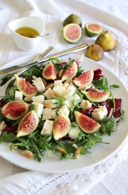 İncirli taze salata, roket salatası, badem ve peynir. Yaz yemeği zamanı. Diyet salatası. Tam üstte.