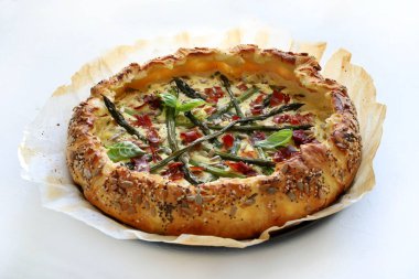 Beyaz arka planda kuşkonmaz, ricotta ve benekli tuzlu turta. Bahar yemeği. Tam üstte. Boşluğu kopyala.