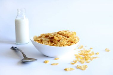 Beyaz kasede mısır gevreği ve beyaz arka planda izole edilmiş süt. Kahvaltı konsepti. Boşluğu kopyala.