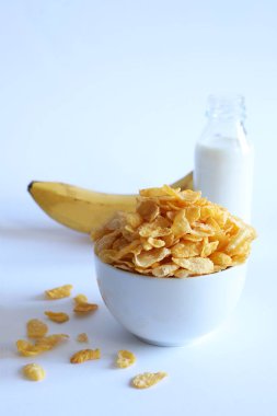 Beyaz kasede mısır gevreği ve beyaz arka planda izole edilmiş süt. Kahvaltı konsepti. Boşluğu kopyala.