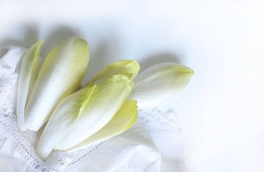 Beyaz arka planda bir grup çiğ hindiba izole edildi. Tam üstte. Uzayı kopyala Vejetaryen yemeği..