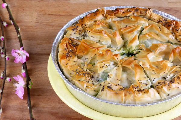 Easter holiday. Concept of greek cuisine. Homemade Spanakopita pie. Greek spinach feta cheese pie on wooden table. Directly above. Copy space.