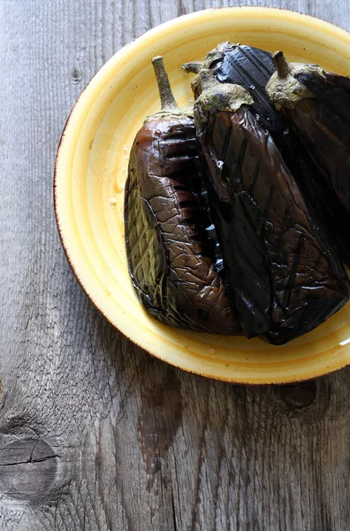 Ahşap arka planda sarı bir tabakta kızarmış patlıcan. Sağlıklı yiyecekler. Vejetaryen ya da vejetaryen yemeği. Yukarıdan görüntüle.