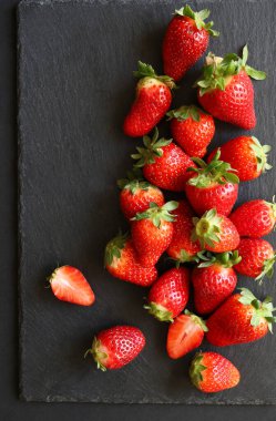 Arka planda bir sürü taze organik çilek var. Sağlıklı meyve kavramı. Uzayı kopyala Tam üstte.