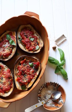 Beyaz arka planda domatesli fırında patlıcan, mozzarella ve fesleğen. Ev yapımı yemek konsepti. Tam üstte.