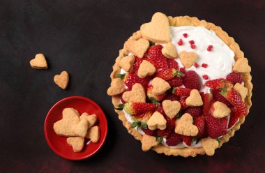 Siyah arka planda izole edilmiş ahududu ve çilekli taze ev yapımı meyveli tart. Sevgililer Günü için lezzetli bir tatlı. Tam üstte. Boşluğu kopyala.