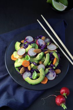 Taze avokado ve koyu arkaplanda badem salatası. Sağlıklı yiyecekler. Tam üstte. Boşluğu kopyala.