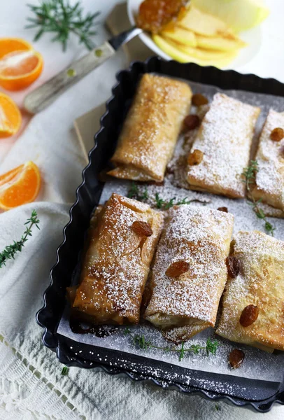 Homemade single portion apple strudel with puff pastry in a tray. Directly above.