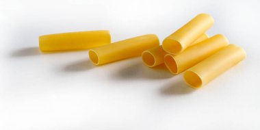 Beyaz arka planda çiğ makarna izole edildi. Cannelloni makarna tüpleri. İtalyan yemeği konsepti. Boşluğu kopyala.