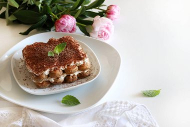 Tiramisu kahvesi. Beyaz arka planda kadın parmaklı ve maskaralık kremalı klasik kahve tiramisusu. İtalyan tatlısı.