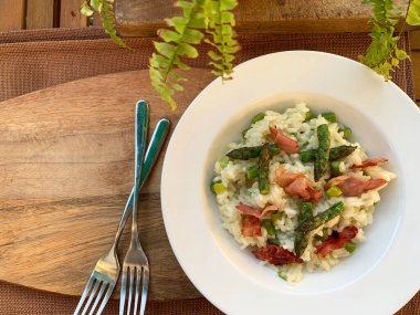 Kuşkonmazlı ev yapımı risotto ve ahşap arka planda benek. Bahar yemeği. İtalyan yemeği. Genel bakış. Boşluğu kopyala.