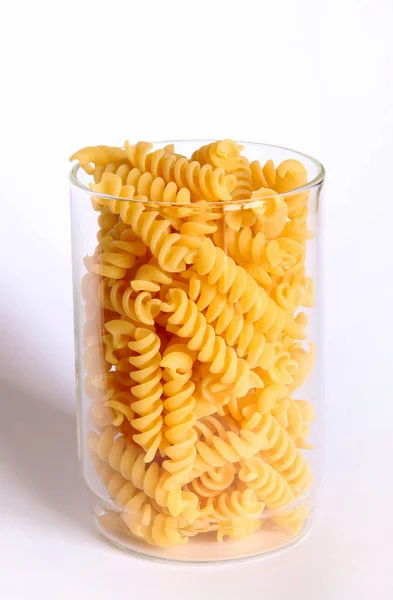 意大利传统面食 未煮熟的富西里面食放在一个玻璃瓶中 与白色背景隔离 面粉产品 健康的有机食品原料 后续行动 — 图库照片