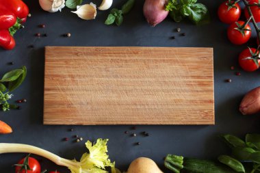 Koyu arka planda kesim tahtası olan çeşitli taze sebzeler. Boşluğu kopyala, Genel Görünüm.