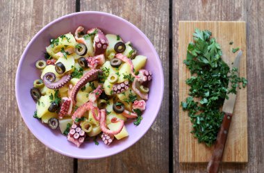 Ahşap arka planda patates, zeytin ve maydanozlu taze ahtapot salatası. Sağlıklı gıda konsepti. Genel Görünüm.