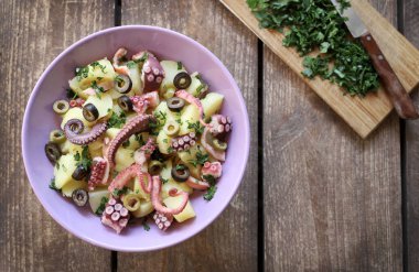 Ahşap arka planda patates, zeytin ve maydanozlu taze ahtapot salatası. Sağlıklı gıda konsepti. Genel Görünüm.