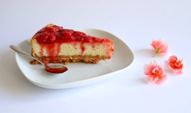 Ev yapımı tatlı konsept. Beyaz arka planda çilekli cheesecake dilimi. Yakın plan, kopyalama alanı.