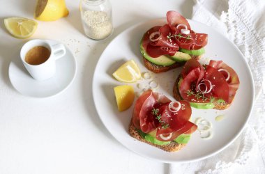 Beyaz arka planda Bresaola (tütsülenmiş et) ile avokado tostu. Sağlıklı gıda konsepti. Genel bakış. Boşluğu kopyala. 