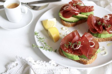 Beyaz arka planda Bresaola (tütsülenmiş et) ile avokado tostu. Sağlıklı gıda konsepti. Genel bakış. Boşluğu kopyala.