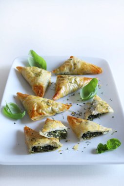 Geleneksel Yunan mutfağı. Spanakopita, beyaz arka planda ıspanaklı, fettalı ve taze dereotlu çıtır fileto..