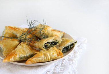 Geleneksel Yunan mutfağı. Spanakopita, beyaz arka planda ıspanaklı, fettalı ve taze dereotlu çıtır fileto..