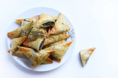 Geleneksel Yunan mutfağı. Spanakopita, beyaz arka planda ıspanaklı, fettalı ve taze dereotlu çıtır fileto..