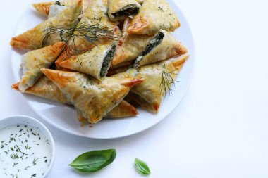 Geleneksel Yunan mutfağı. Spanakopita, beyaz arka planda ıspanaklı, fettalı ve taze dereotlu çıtır fileto..