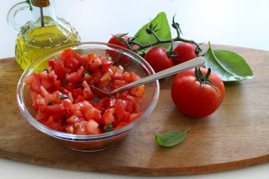 İtalyan yemeği konsepti. Küçük parçalara ayrılmış taze domatesler ve bruschetta için kekik, fesleğen ve zeytinyağı ile tatlandırılmış. Aperatif yemek..