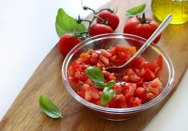 İtalyan yemeği konsepti. Küçük parçalara ayrılmış taze domatesler ve bruschetta için kekik, fesleğen ve zeytinyağı ile tatlandırılmış. Aperatif yemek..