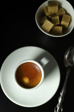 İtalyan içeceği kavramı. Siyah arka planda klasik beyaz bir fincan espresso. Yakın plan. Genel Görünüm.