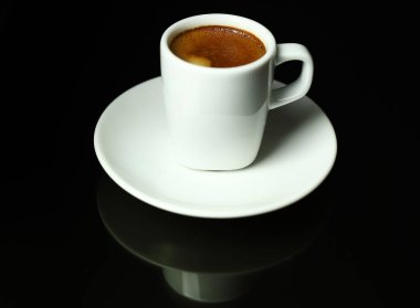 İtalyan içeceği kavramı. Siyah arka planda klasik beyaz bir fincan espresso. Yakın plan. Genel Görünüm.