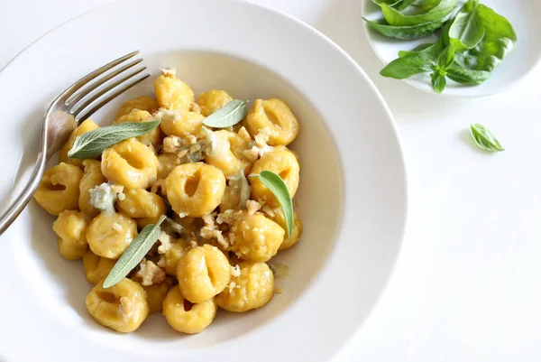 Stock image Italian food concept. Gnocchi with gorgonzola cream and walnuts on white background. Overhead view.