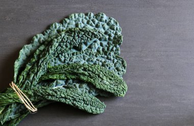 Siyah İtalyan lahanası gri arka planda izole edilmiş. Vejetaryen yemeği. Genel bakış. Boşluğu kopyala.