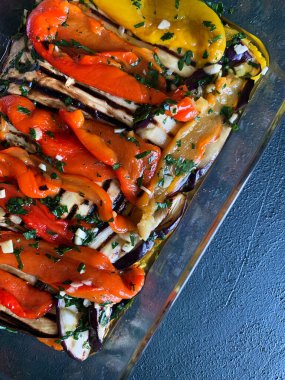 Ev yapımı kavrulmuş maydanozlu, sarımsaklı, sirkeli ve gri arka planda zeytinyağlı dolmalık biber. Vejetaryen yemeği. Genel Görünüm.