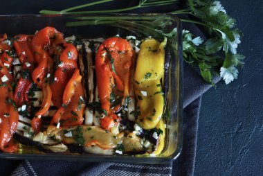 Ev yapımı kavrulmuş maydanozlu, sarımsaklı, sirkeli ve gri arka planda zeytinyağlı dolmalık biber. Vejetaryen yemeği. Genel Görünüm.