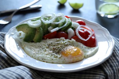 Yağda yumurta ve avokado, domates, beyaz tabakta sebze. Sağlıklı kahvaltı kavramı. Genel manzara, düz yatış. Boşluğu kopyala.