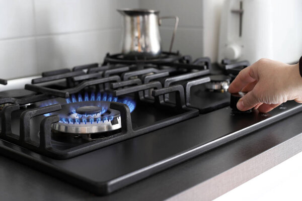 Крупный план голубого огня с кухонной плиты с пропановым газом. Плита. Кризис газа. Рост цен.