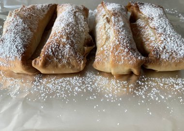 Gri arka planda pudra şekeri serpiştirilmiş ev yapımı elmalı turta. Apfelstrudel. Genel Görünüm.