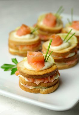 Somon füme ekmeği ve beyaz tabakta krem peynirli kanepe. Lezzetli aperatif. Yakın plan. Genel Görünüm.