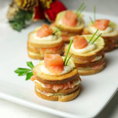 Somon füme ekmeği ve beyaz tabakta krem peynirli kanepe. Lezzetli aperatif. Yakın plan. Genel Görünüm.