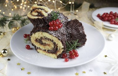 Geleneksel Noel tatlısı. Buche de Noel. Çikolata kremalı ve üzümlü Noel pastası. Tatil sezonu.
