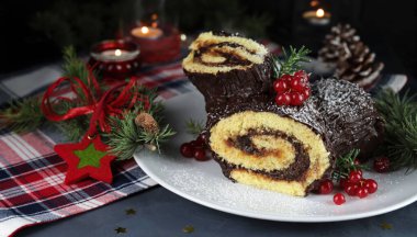 Geleneksel Noel tatlısı. Buche de Noel. Çikolata kremalı ve üzümlü Noel pastası. Tatil sezonu.