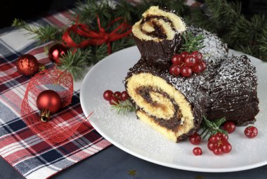 Geleneksel Noel tatlısı. Buche de Noel. Çikolata kremalı ve üzümlü Noel pastası. Tatil sezonu.